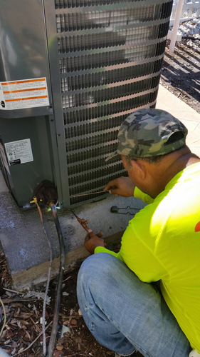 Professional technician performing rooftop commercial HVAC service